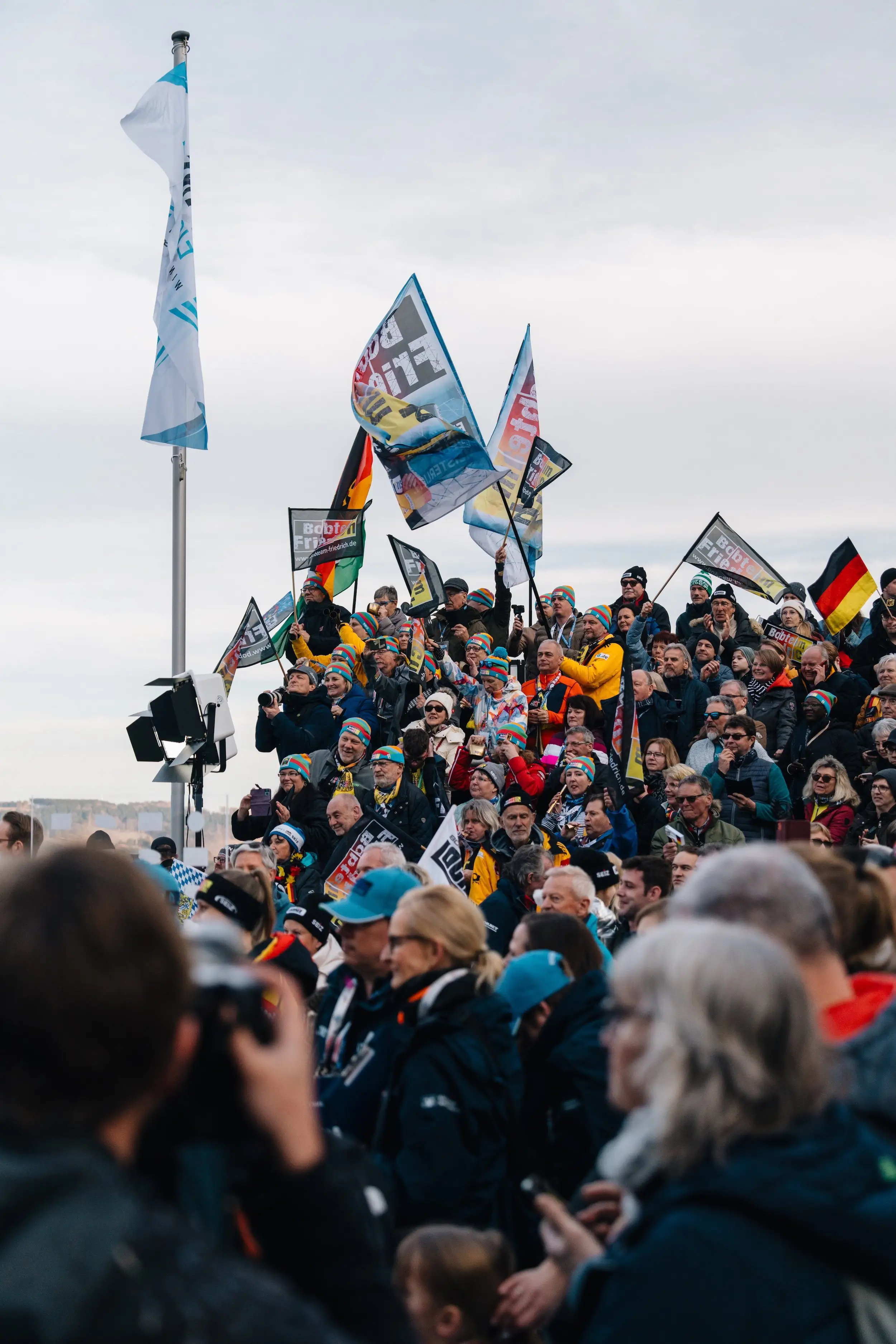 Spectators with German flags and a photographer in the crowd