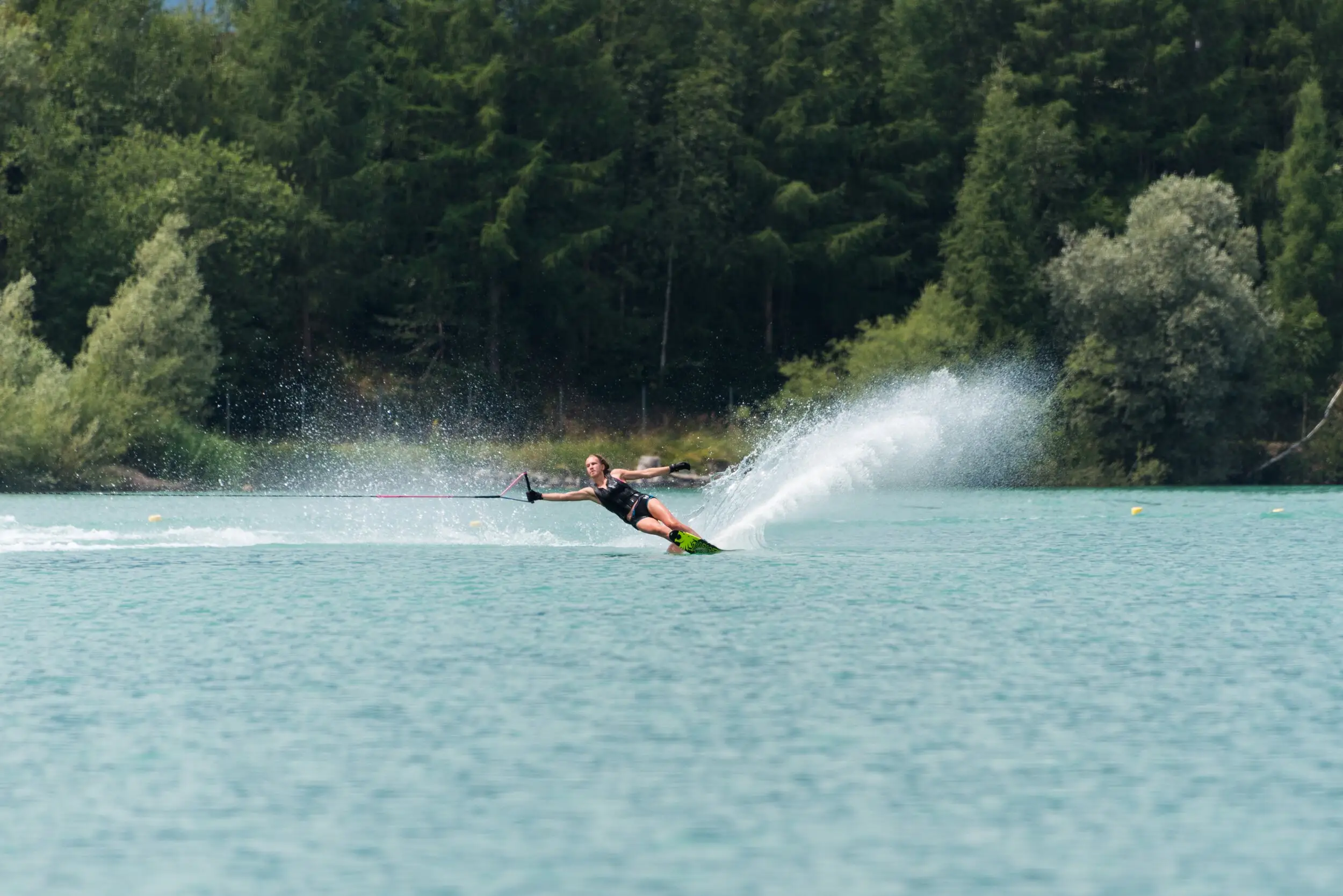 A water-skier cutting through the lake with a wall of spray